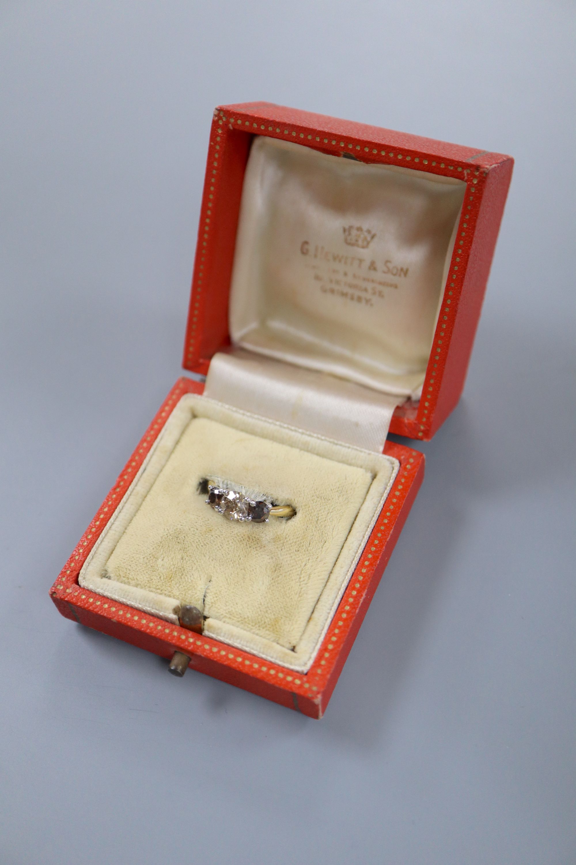 A modern 18ct gold and platinum, three stone two colour diamond set ring, size M, gross weight 3.5 grams.